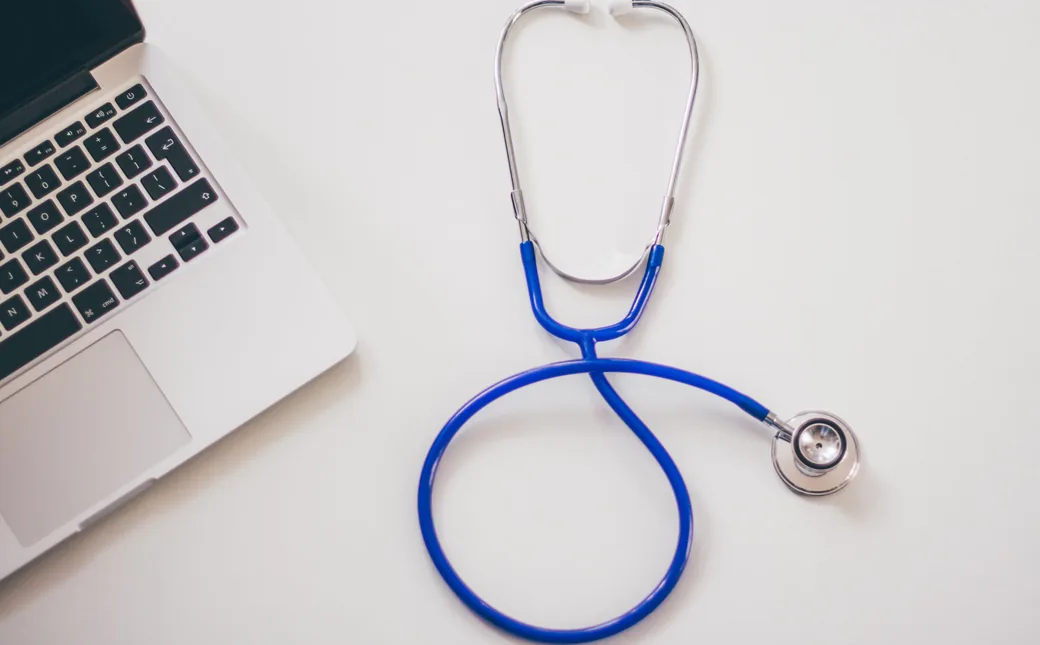Computadora y estetoscopio preparados para telemedicina, foto de referencia
